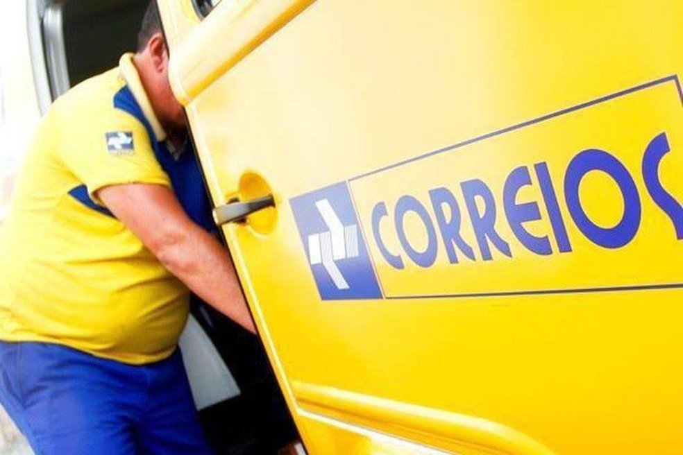 Ministro defende privatização dos Correios em pronunciamento #Pracegover Na foto, funcionário do Correio tirando encomenda de um carro