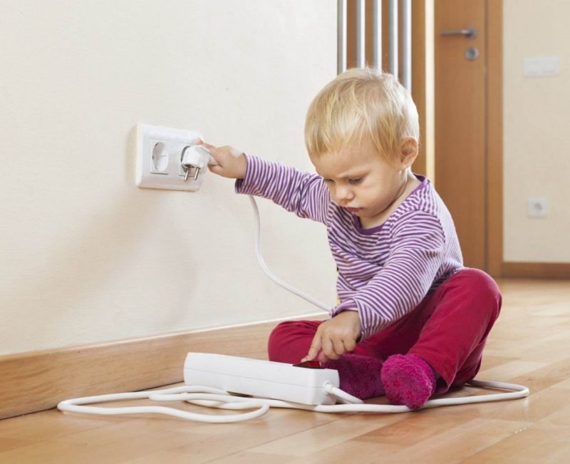 acidente-domestico-comum #Pracegover foto: na imagem há uma criança, porta, tomada e fio elétrico