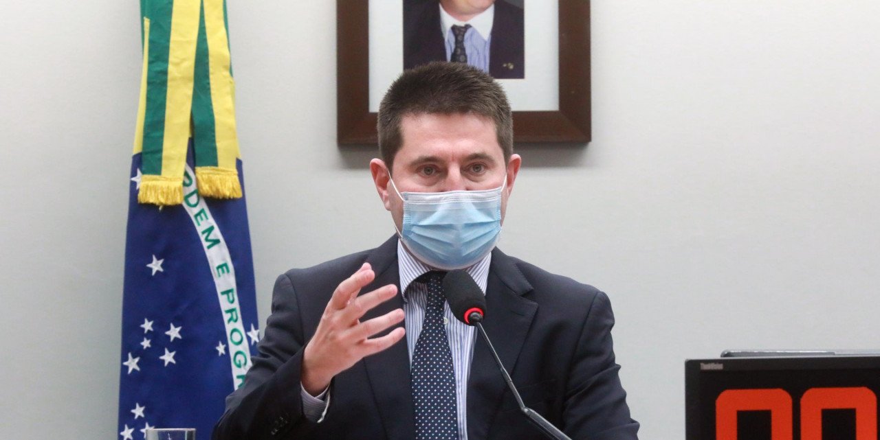 deputado #Pracegover foto: na imagem há um homem de terno e uma bandeira