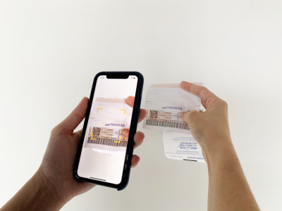 Fatura QR #Pracegover foto: na imagem há duas mãos e braços, um celular e fatura