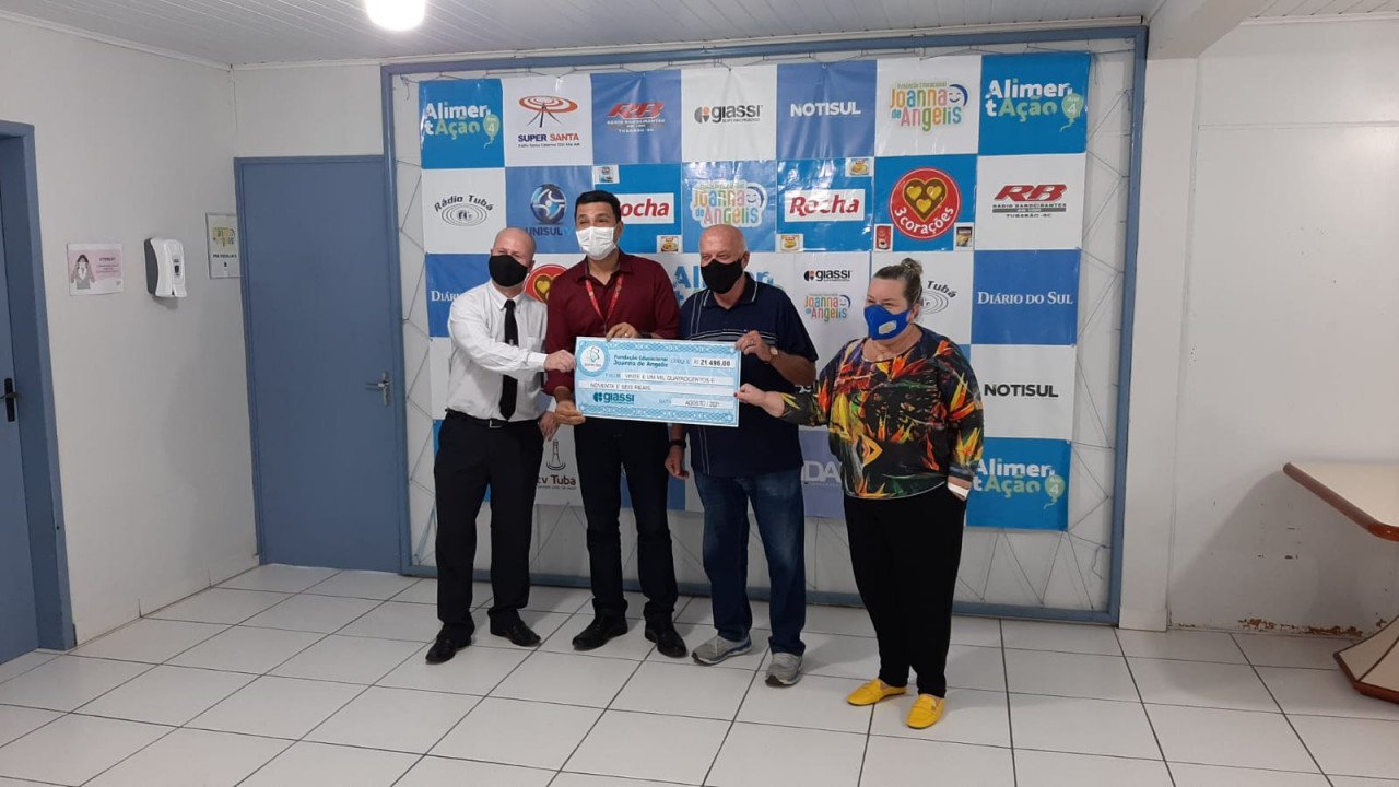 joanna #Pracegover foto: na imagem há 4 pessoas e um cheque simbólico