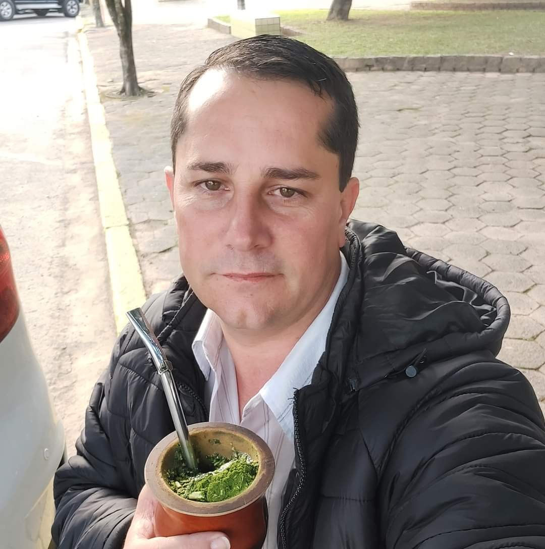 Farofa #Pracegover foto: na imagem há um homem de camisa branca e um corta vento escuro. Nas mãos há uma cuia de chimarrão