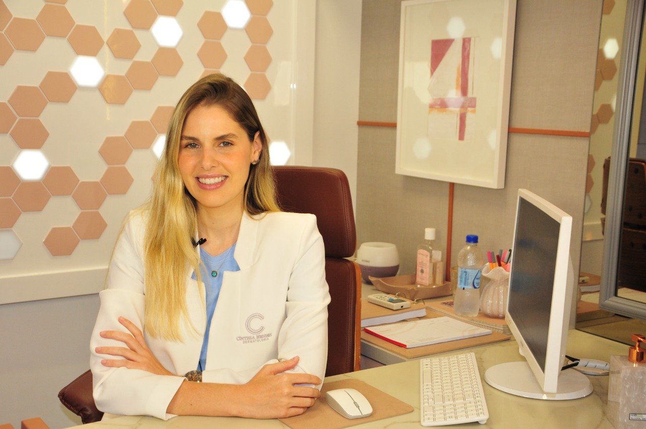 medica provida #Pracegover foto: na imagem há uma mukher com roupa branca, uma mesa, computador, e acessórios na mesa