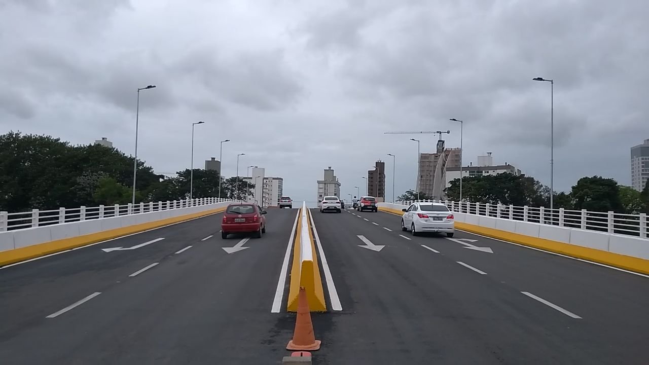 TRÂNSITO #Pracegover foto: na imagem há uma ponte, veículos, postes e prédios