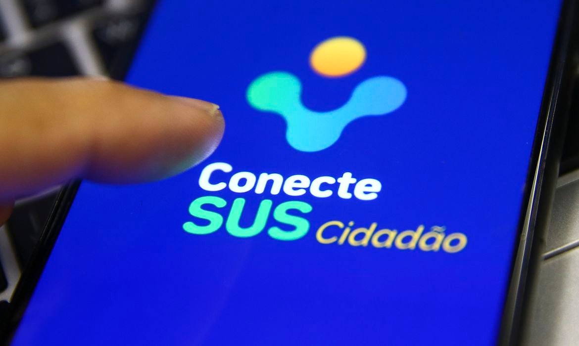 aplicativo-conecte-sus #Pracegover Foto: na imagem há um celular e um dedo