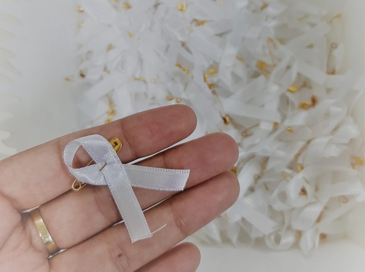 janeirobranco #Pracegover Foto: na imagem há uma mão e vários laços da cor branca