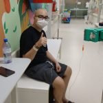 #Pracegover Foto: na imagem há um jovem de máscara, óculos, bermuda e camiseta escura