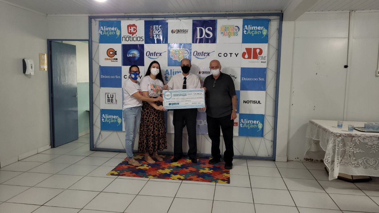 Joanna #Pracegover Foto: na imagem há 4 pessoas segurando um cheque simbólico