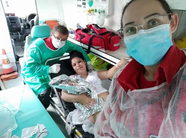 parto na BR-101 #PraCegoVer Na foto, uma mãe com seu bebê e dois bombeiros voluntários