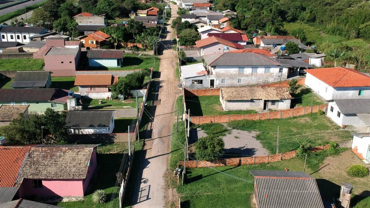 Estrada Geral do Estreito #PraCegoVer Na foto, a imagem área de uma estrada sem pavimentação circundada por várias casas e pequenos prédios