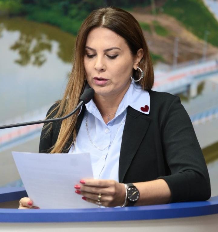 luciane torkaski #PraCegoVer Na foto, uma mulher segura um papel e lê o que está escrito no microfone