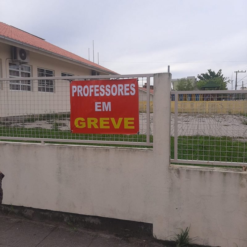 greve #Pracegover Foto: na imagem há uma construção, grades e um cartaz