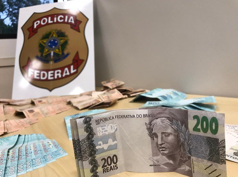 Dinheiro Falso Polícia Federal #PraCegoVer Na foto, notas de dinheiro falso e o simbolo da Polícia Federal