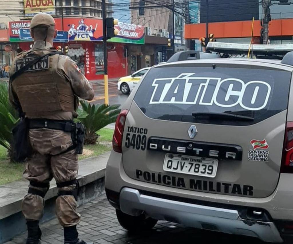 Tático Tubarão #PraCegoVer Na foto, um policial de costas ao lado de uma viatura
