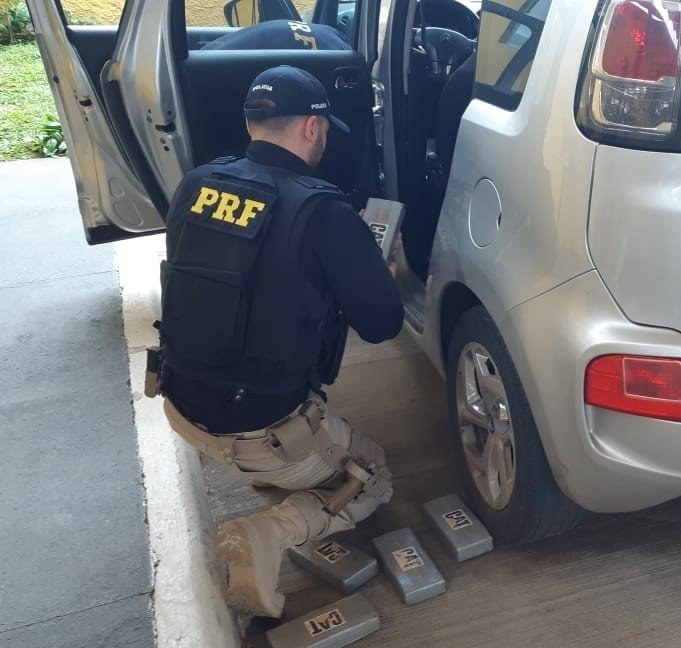cocaína PRF #PraCegoVer Na foto, um policial retira tabletes de drogas de dentro de um carro