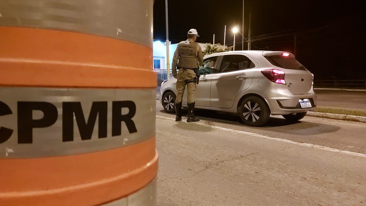 PMRv 3 #PraCegoVer Na foto, Um policial aplica o teste do etilômetros em uma motorista
