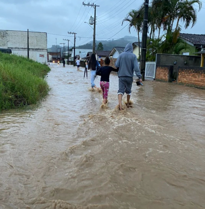 Grão-Pará #PraCegoVer Na foto, moradores fogem de alagamentos