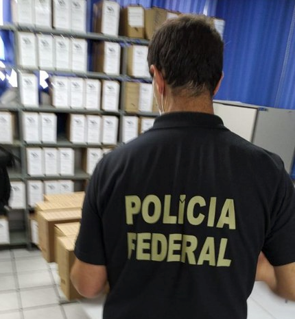 Operação Fuscus #PraCegoVer Na foto, um agente de Polícia Federal faz o recolhimento de documentos em uma empresa acusada de superfaturamento na compra de materiais médicos e hospitalares destinados à rede pública de saúde