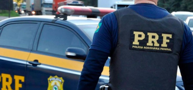 PRF #ParaTodosVerem Na foto, uma viatura da Polícia Rodoviária Federal e um policial uniformizado na frente
