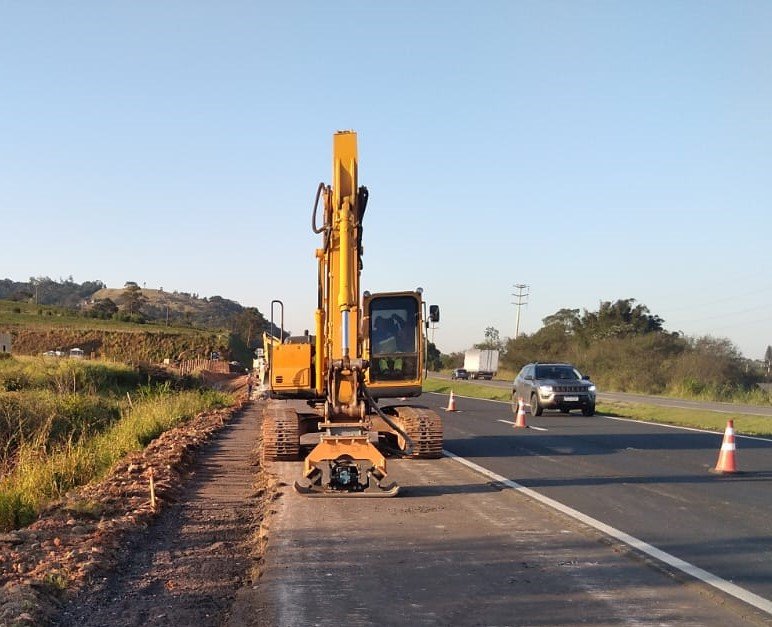 Melhorias BR-101 #ParaTodosVerem Na foto, um trabalhador, dentro de um máquina amarela, faz obras de melhorias na BR-101
