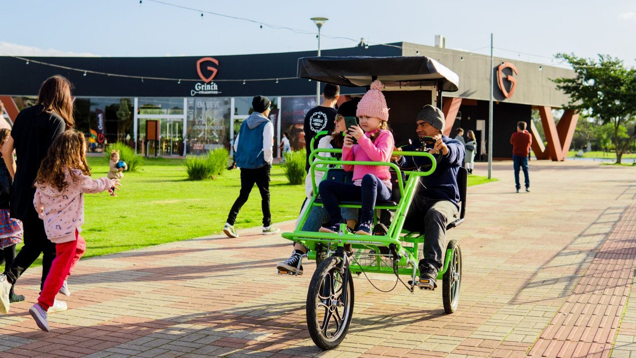 parque #Pracegover Foto: na imagem há pessoas, brinquedos, construção, calçada e gramado