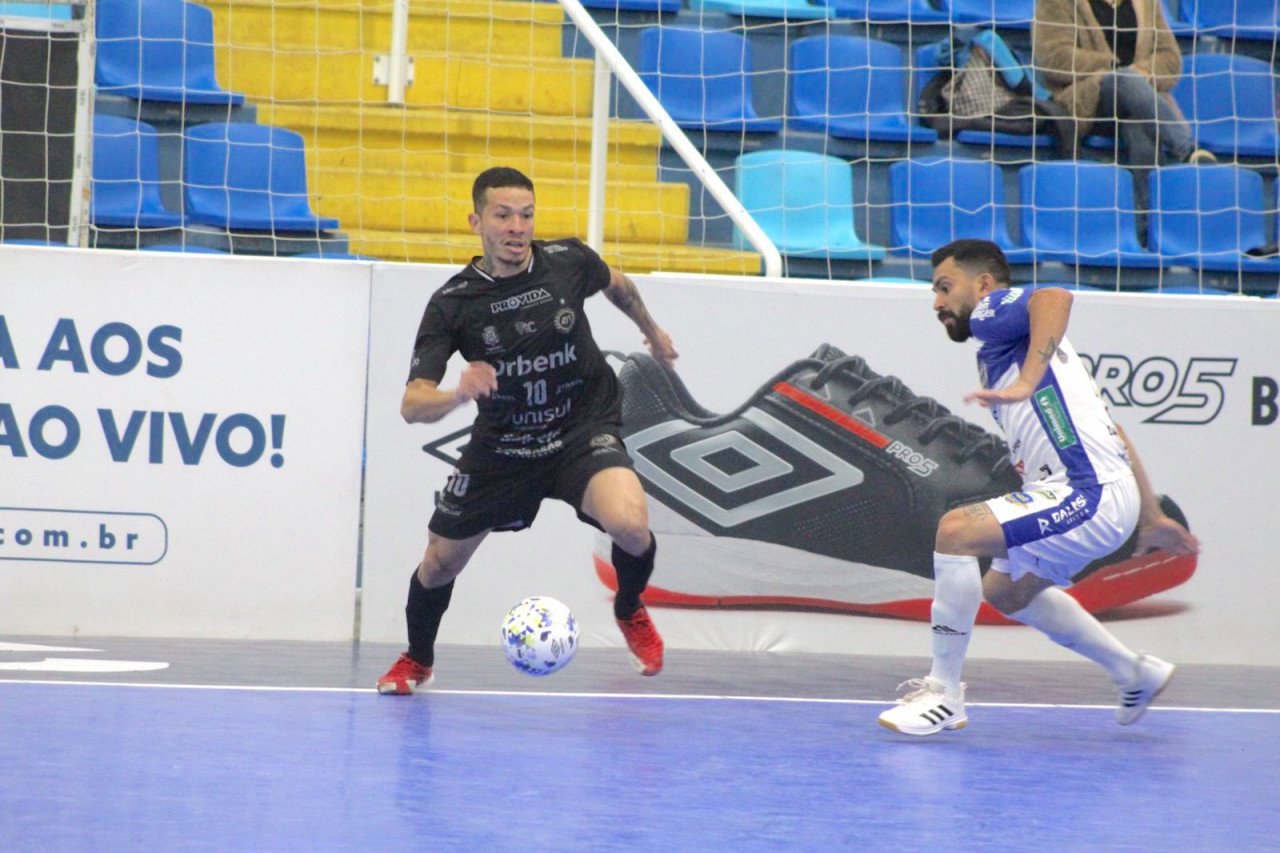 8fea6ff4-ff7b-4c7a-b749-5745ec3cb788 #ParaTodosVerem Na foto, dois jogadores de futsal disputam a posse de bola