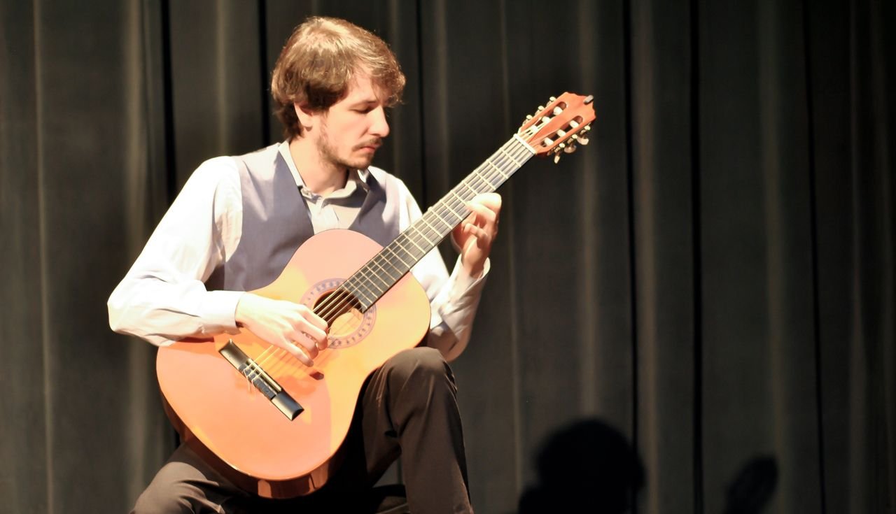 Pedras Grandes 2 #ParaTodosVerem Na foto, um homem toca violão