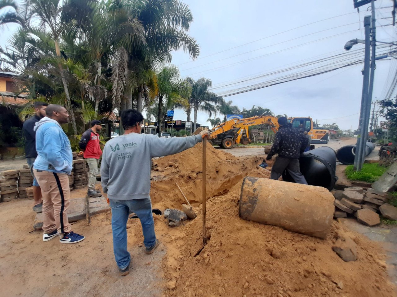rosa #ParaTodosVerem Na foto, homens trabalham na pavimentação de uma rua