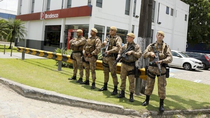 PM Blumenau Policiais armados, fardados, formando coluna próximo a agência bancária