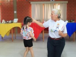 Escritora interage com criança durante contação de história em escola